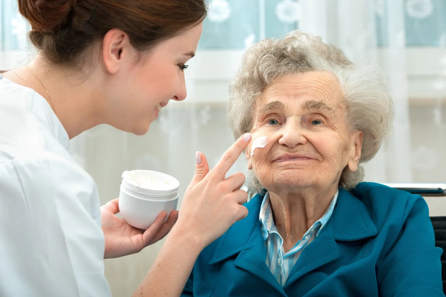 ALLTAGSBEGLEITUNG - Ältere Frau wird zu Hause von einer Krankenschwester unterstützt