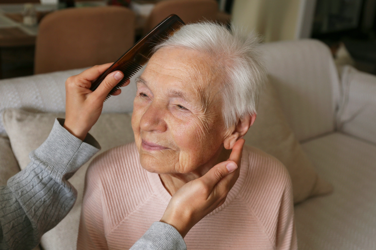 ALLTAGSBEGLEITUNG - Unbekannte Frau kämmt einer älteren Dame die Haare